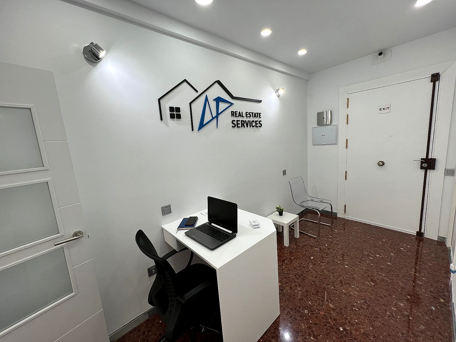 Oficina de AP Real Estate Services en Almería, con el logotipo de la agencia en la pared